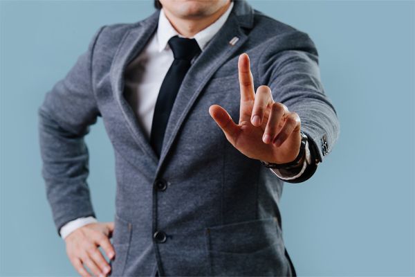 © zzzdim - stock.adobe.com Foto: Person mit ausgestrecktem Finger und Krawatte