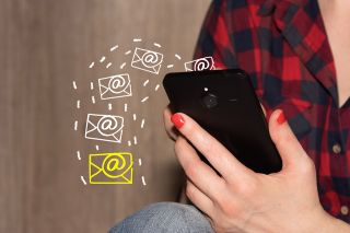 Foto: Frau hält Mobiltelefon in der Hand